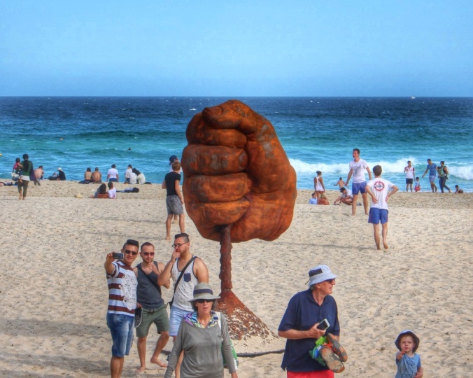 Visitors to Sculpture by the Sea, Bondi, NSW, Australia pose by Norton Flavell's sculpture 'Dust.' Image: Su Leslie, 2015