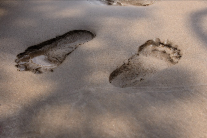 close up shot of foot prints in sand -- right foot moving forward, left foot moving back. Image: Su Leslie, 2017
