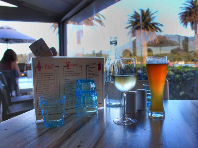 Glass of white wine and glass of beer on table at Stoked cafe, Whitianga, NZ. Image: Su Leslie, 2017