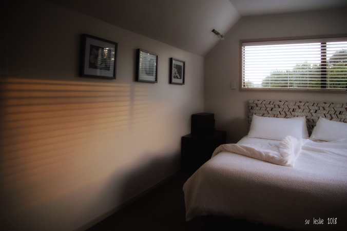 Shot of filtered morning light on bedroom wall. Turned-back bed. Image: Su Leslie, 2018