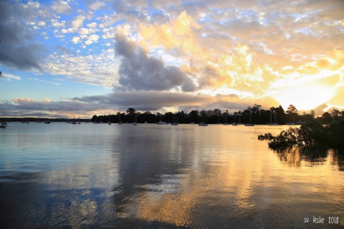 Sunset over Herald Island from Rahui Beach, Greenhithe. Cloud reflections on water. Image: Su Leslie, 2018