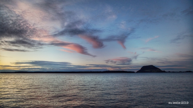 Sunset, Tauranga Harbour, New Zealand. Mt Maunganui in the distance. Wispy pink clouds. Image: Su Leslie 2019